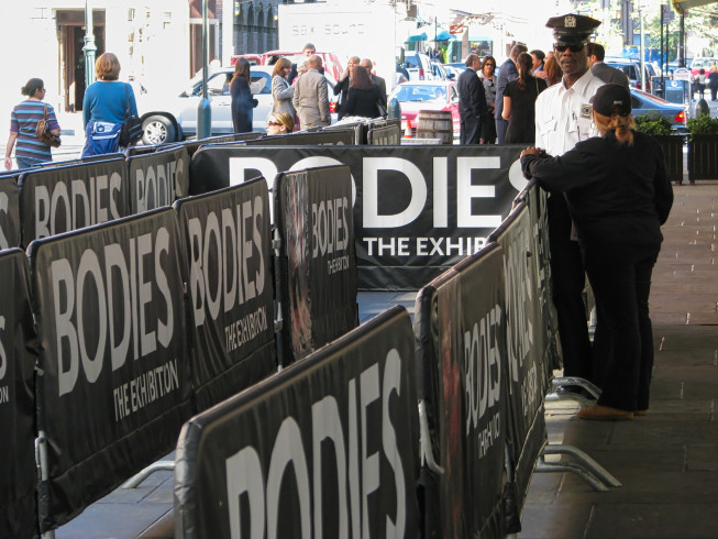 Two NYPD police officers stand guard outside the Bodies Exhibition in New York